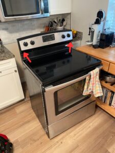 Amana glass-top range with "burner not heating" issue and arrows, showing how exactly to take the control panel off