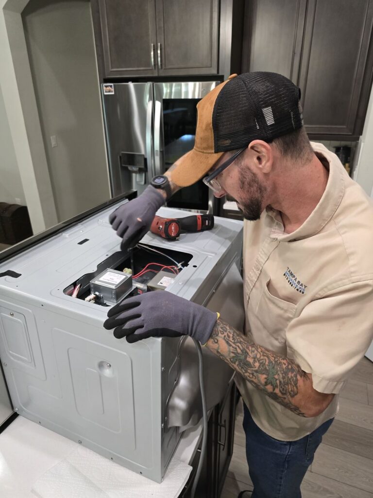 Technician repairing a washer in a customer kitchen