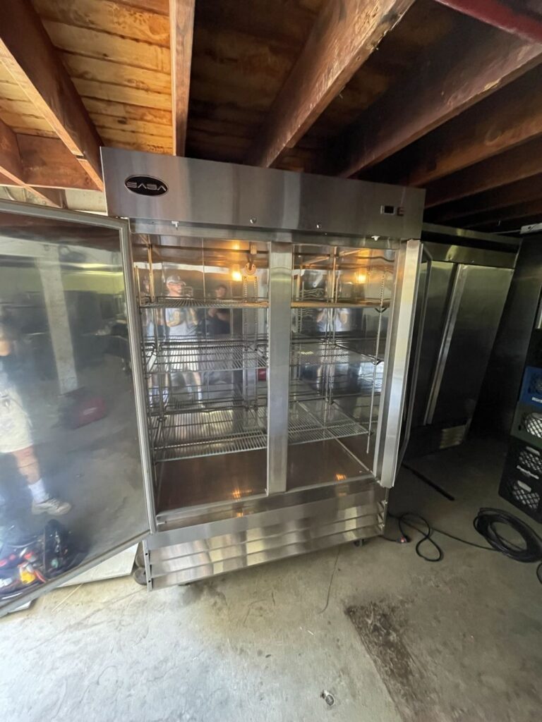 Commercial two door reach-in refrigerator being serviced