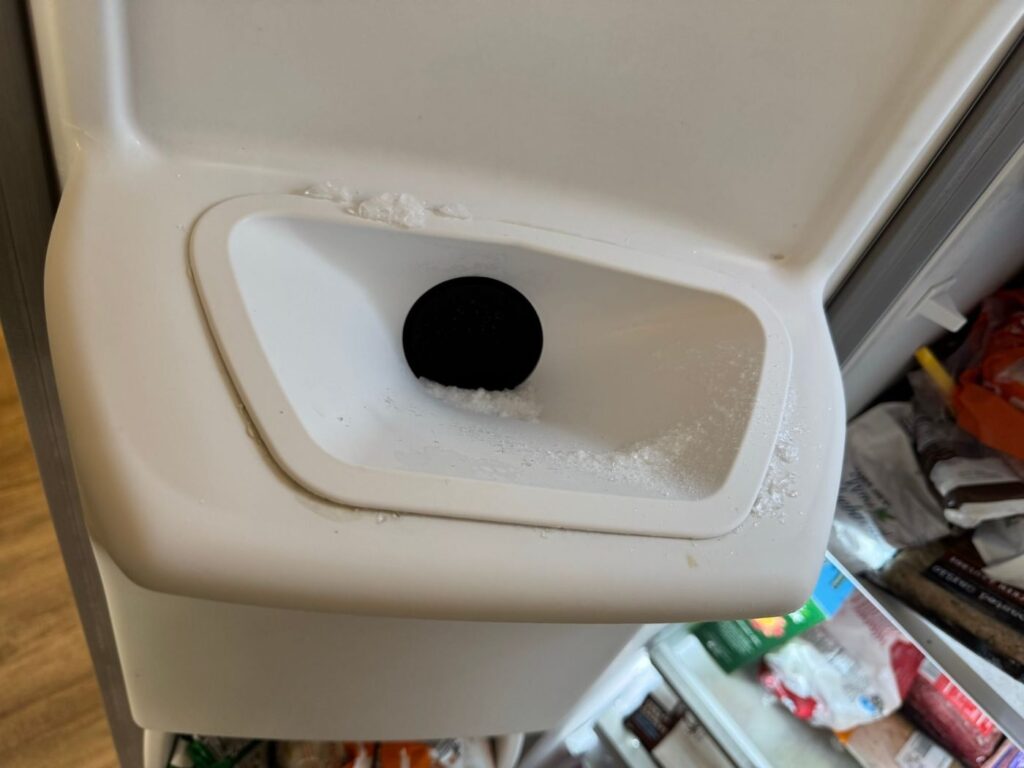 Ice dispenser chute on a Frigidaire side-by-side refrigerator