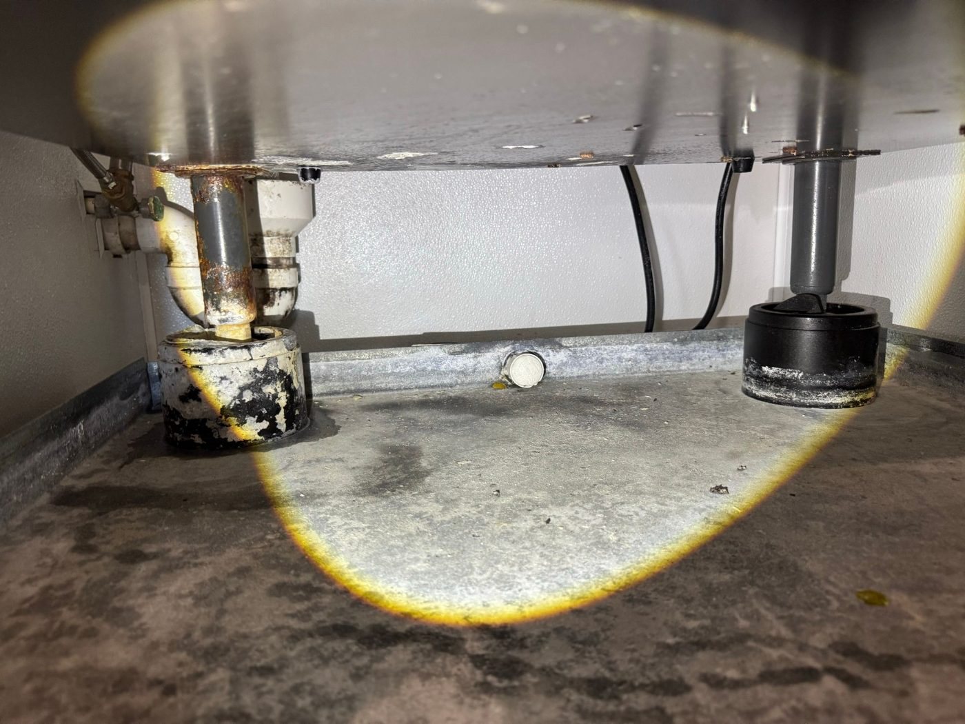 Mineral residue on the floor under a Manitowoc ice machine from a pump leak