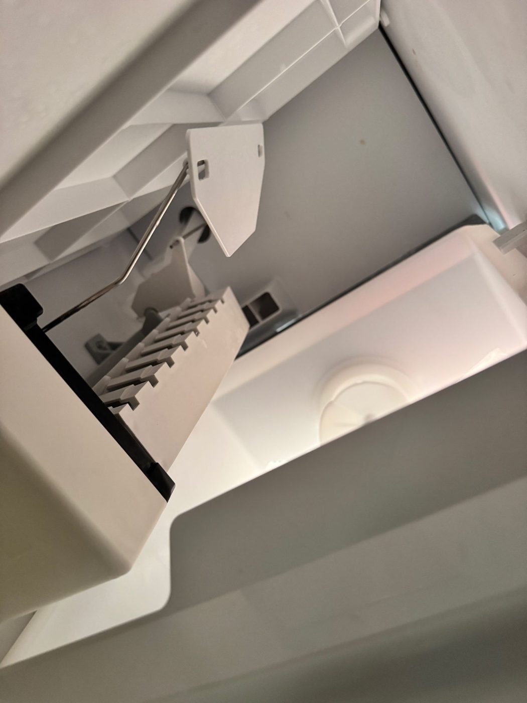 Ice maker assembly in a side by side refrigerator freezer