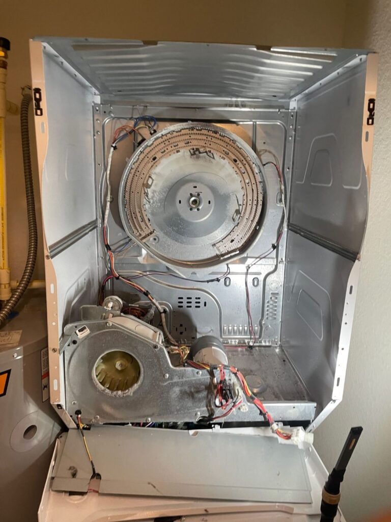 Stacked dryer opened up with the drum removed for inspection